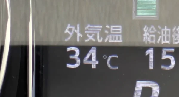 車の外気温計が 34 度を示している写真。